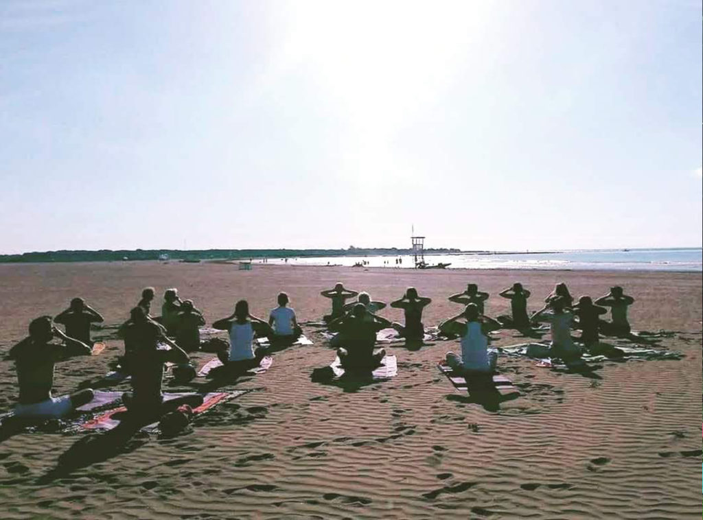 yoga di gruppo al mare